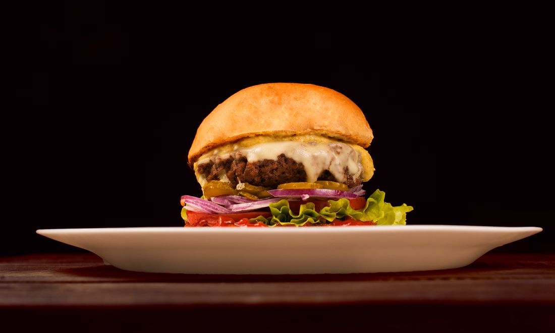 A double bacon cheeseburger on a plate.