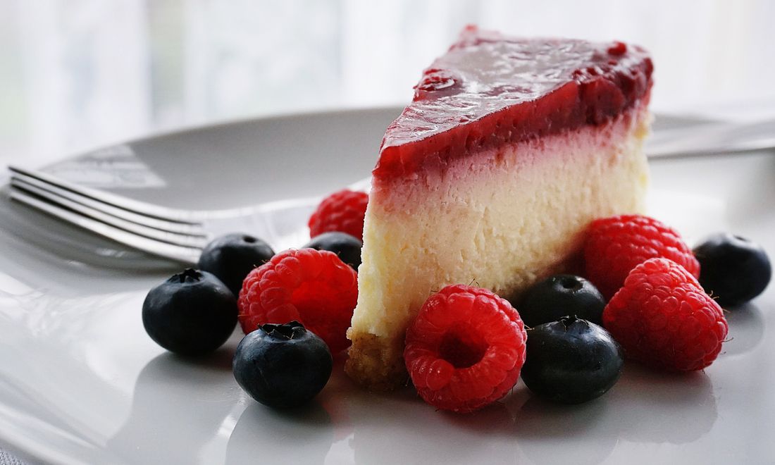 A slice of homemade cheesecake with fresh berries.